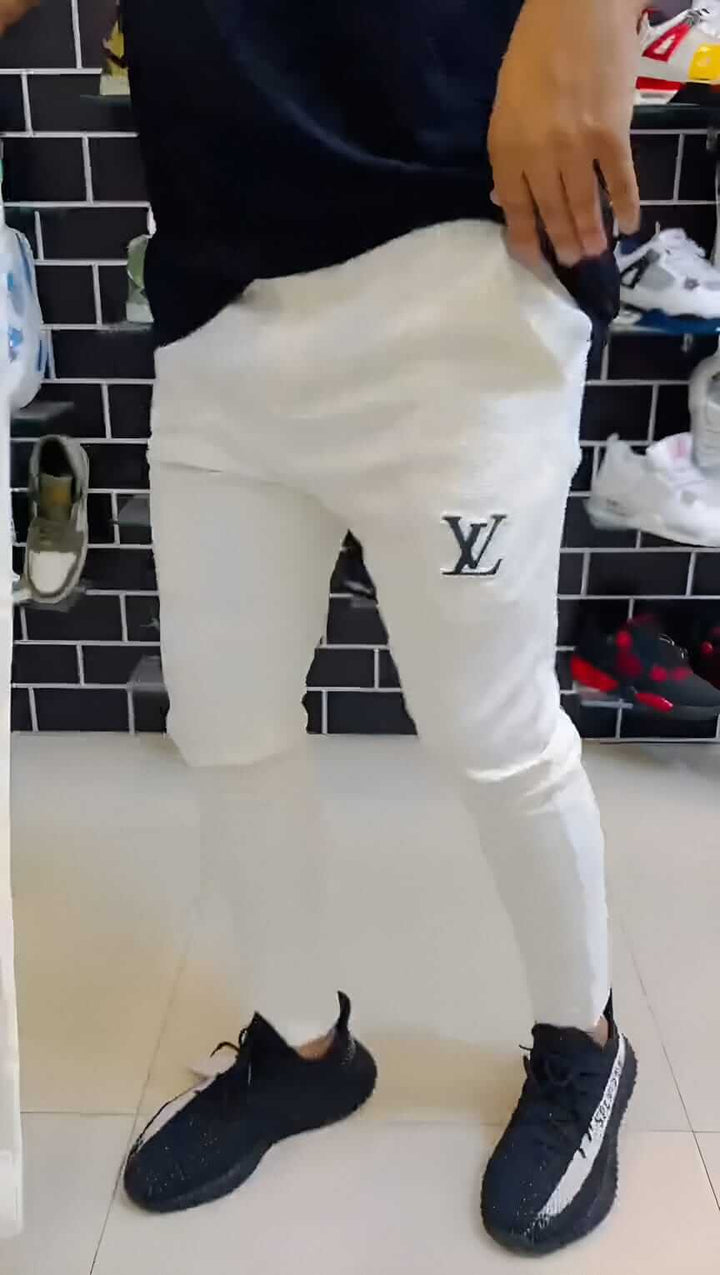 Man wearing LV Signature Luxury Trouser in white with logo, showcasing luxury and tailored style.